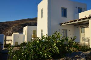 a white building with a bush in front of it at Vorina Ktismata in Amorgos