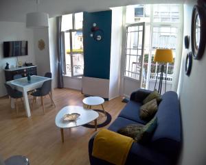 sala de estar con sofá azul y mesa en Le Ginkgo biloba, en Luchon