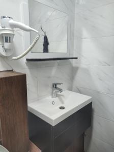 uma casa de banho com um lavatório branco e um espelho. em Apartment on Zarwanska Street em Kamianets-Podilskyi