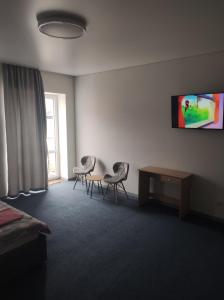 um quarto com duas cadeiras e uma mesa e uma televisão em Apartment on Zarwanska Street em Kamianets-Podilskyi