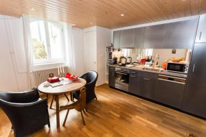 a kitchen with a table and chairs and a kitchen with a stove at Luxury Apartments Justingerweg Bern in Bern