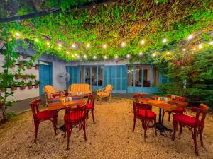 a patio with wooden tables and chairs and lights at Via Mina Hotel in El Mîna