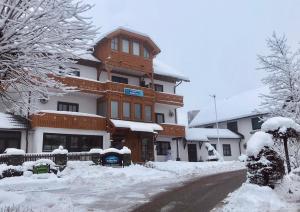 a large building with snow on the ground at Pension Kärnten in Seeboden