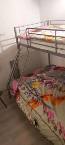 ein Etagenbett mit einer Blumendecke auf einem Regal in der Unterkunft Klepperstee Esdoorn 3 in Ouddorp
