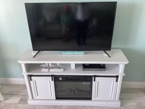 a tv on a white entertainment center with a television at Ocean Walk Resort - Striking Ocean Front View in Daytona Beach