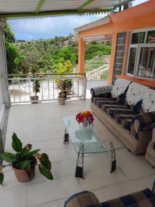 une terrasse avec un canapé et une table en verre dans l'établissement La Belle du Sud, à Rodrigues Island