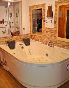 un bagno con grande vasca bianca di Ferienwohnungen Woidzauber a Zwiesel