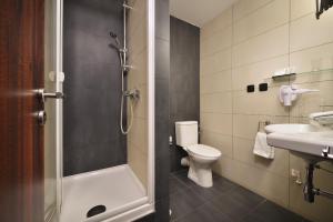 a bathroom with a shower and a toilet and a sink at Parkhotel Morris Novy Bor in Nový Bor