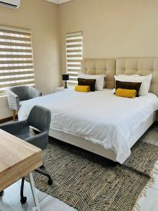 Un dormitorio con una gran cama blanca y una silla. en Ultimate Sky-3 bedroom villa, en Pretoria