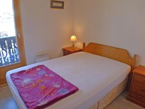 a bedroom with a bed with a purple blanket on it at Appartement Samoëns, 4 pièces, 6 personnes - FR-1-629-87 in Samoëns