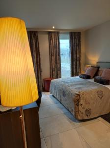 um quarto com uma cama e um candeeiro amarelo em B&B de Taller-Hoeve em Maasmechelen