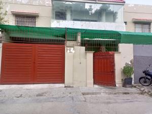 un edificio con dos puertas rojas de garaje en una calle en Karachi Guest House & Couple Hotel, en Karachi