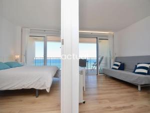 ein weißes Schlafzimmer mit einem Bett und einem Sofa in der Unterkunft Beach Palace B-2 in Platja  d'Aro