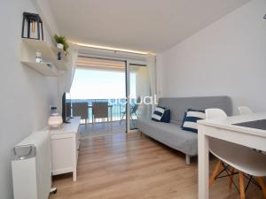 ein Wohnzimmer mit einem Sofa und einem Tisch in der Unterkunft Beach Palace B-2 in Platja  d'Aro