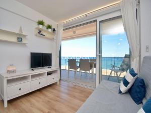 ein Wohnzimmer mit einem TV und einem Balkon in der Unterkunft Beach Palace B-2 in Platja  d'Aro