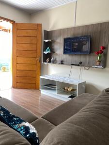 sala de estar con sofá y TV en la pared en Apartamento Petri, en Gramado
