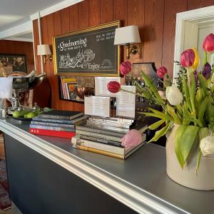 a table with books and flowers on top of it at Park Hotel in Frederikshavn