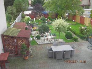 un patio con mesa y sillas y un jardín en Ferienhaus in Kolberg mit Grill, Terrasse und Garten en Kołobrzeg