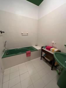 Chambre sur la falaise de Pontaillac في فو سور ميه: حمام مع حوض أخضر ومغسلة
