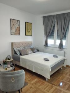 een slaapkamer met een bed en een bank bij Stan na dan Zvornik in Zvornik