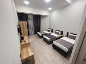 um quarto de hotel com duas camas e uma televisão em Rever Hotel em Tashkent