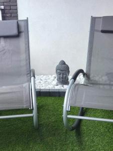een standbeeld van een hoofd op een bed naast een stoel bij BRUSSELS EXPO APARTMENT in Brussel