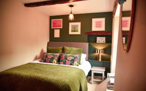 1 dormitorio con paredes verdes y 1 cama con almohadas en The Folly, en Sedbergh