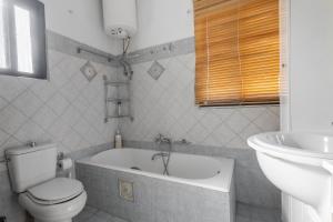 a bathroom with a toilet and a tub and a sink at Delight apartment LA in Larisa