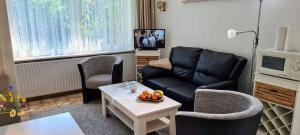 una sala de estar con un sofá y una mesa en FeWo-Hennings, en Olsdorf