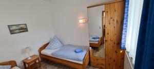 Una pequeña habitación con dos camas y un espejo. en FeWo-Hennings, en Olsdorf 12 fotos más