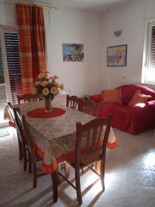 un soggiorno con tavolo e divano rosso di Beb VILLA DORA a Castro di Lecce