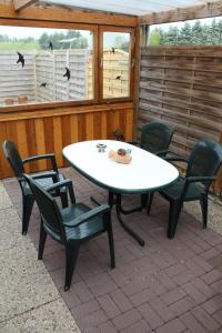 um pátio com uma mesa e cadeiras num pátio em Wohnung in Wilhelmsfehn mit Terrasse, Garten und Grill em Wiesmoor