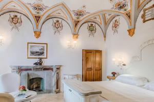 1 dormitorio con 1 cama y chimenea en Monastero Di Cortona Hotel & Spa, en Cortona