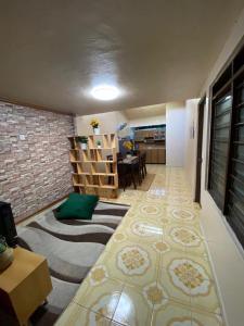 Habitación con sala de estar y comedor. en EMIRDA HOMESTAY (TMN ANDA IPOH), en Ipoh