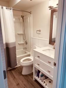 a white bathroom with a toilet and a sink at North Star Place 1 in Fairbanks