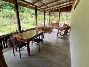 a wooden table and chairs on a screened in porch at Casa Briza in Nicoya