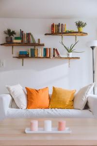 sala de estar con sofá y almohadas de color naranja y blanco en Idyllisches Landhaus mit Teich, 