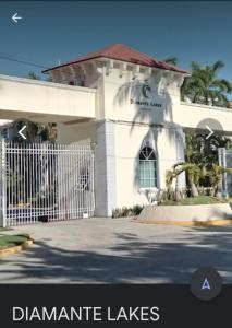 Biały budynek z bramą przed nim w obiekcie Hermoso Depa en Diamante Lakes Frente Arena GPN w Acapulco