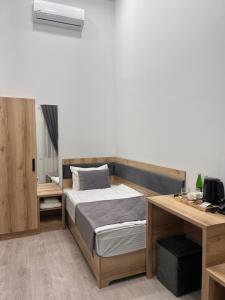 a bedroom with a bed and a desk with a computer at Rever Hotel in Tashkent