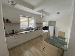 a kitchen with white cabinets and a table in it at Apartament w Wiśle in Wisła