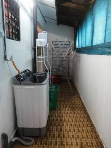 una pequeña habitación con un cubo de basura en un garaje en EMIRDA HOMESTAY (TMN ANDA IPOH), en Ipoh