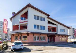 a building with a car parked in a parking lot at Apartments DIEM in Samokov