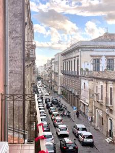 uma rua da cidade com carros estacionados na rua em Civicocento Charming Rooms em Catânia