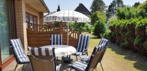 - une table et des chaises avec un parasol sur la terrasse dans l'établissement Ferienwohnung-Floppy-Hansi-Fewo-4-EG, à Sankt Peter-Ording