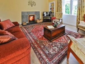 a living room with a couch and a fireplace at Shepherds Cottage in Stenton