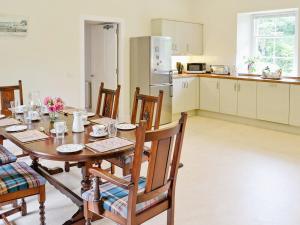 uma cozinha e sala de jantar com uma mesa de madeira e cadeiras em Shepherds Cottage em Stenton