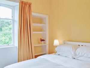 um quarto com uma cama branca e uma janela em Shepherds Cottage em Stenton