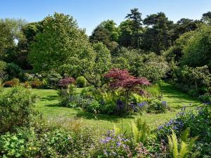 a garden with lots of flowers and trees at Shepherds Cottage in Stenton