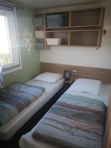 twee bedden in een kamer met een raam bij Mobile Homes Sous le Soleil in Valras-Plage