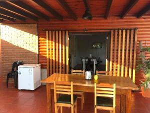 una mesa de madera con sillas y una cafetera. en Hermosa y confortable cabaña en Puerto Iguazú